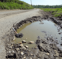 A deep pothole on Blackwall Road, Hinxhill near Goose Green Farm